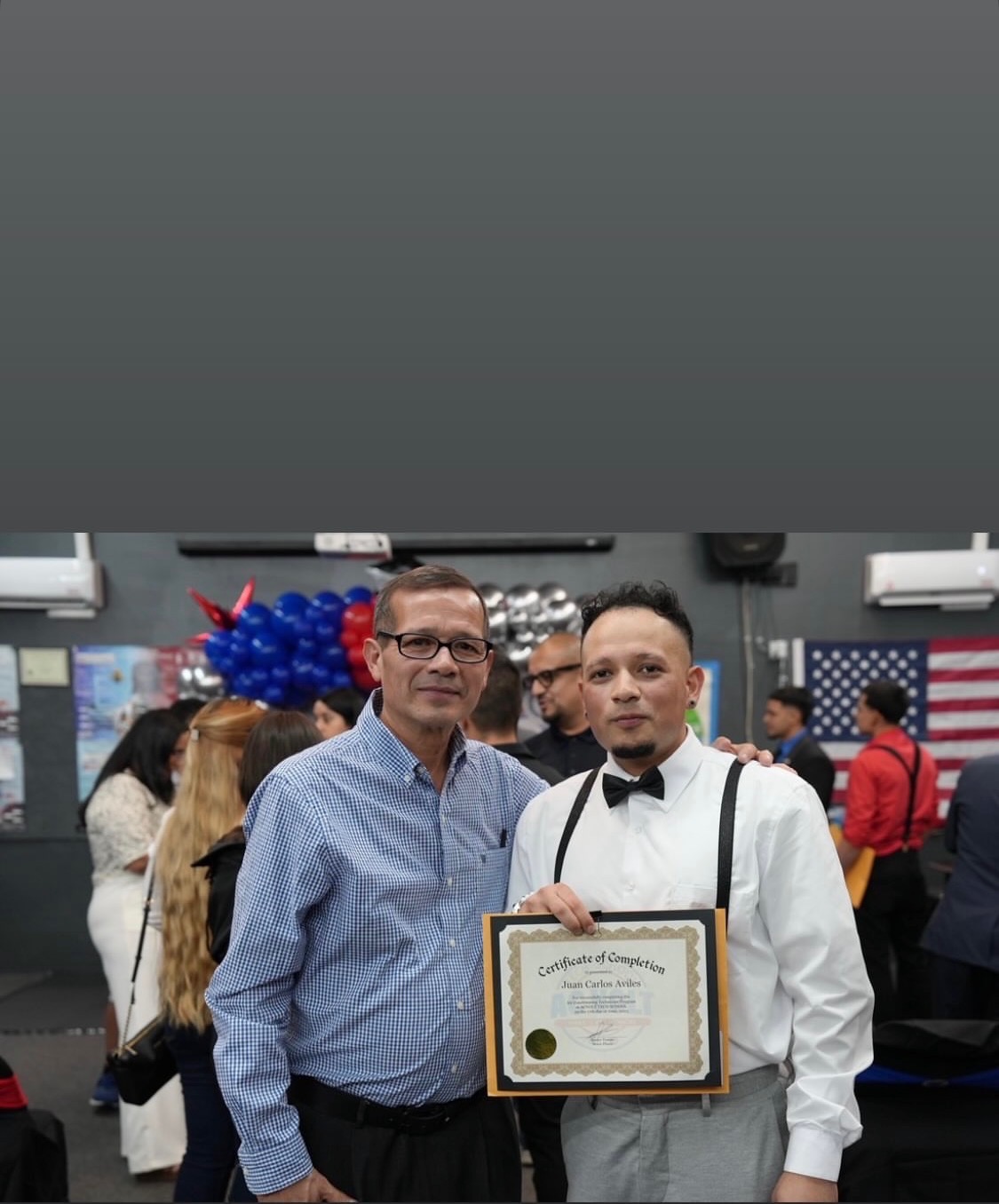 Estudiante mostrando su certificado junto a un acompañante